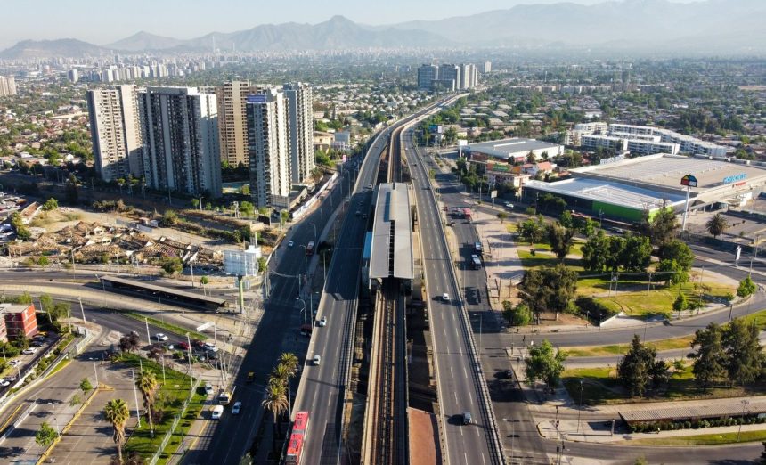 Vista aérea de uma rodovia urbana entre edifícios e áreas construídas de Santiago, no Chile.